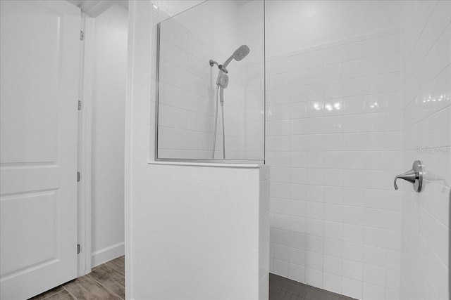 bathroom with hardwood / wood-style floors and tiled shower