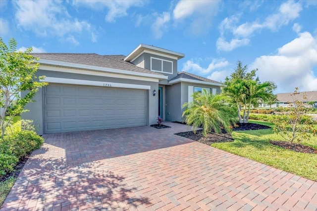 view of front of home with a garage, stucco siding, and decorative driveway