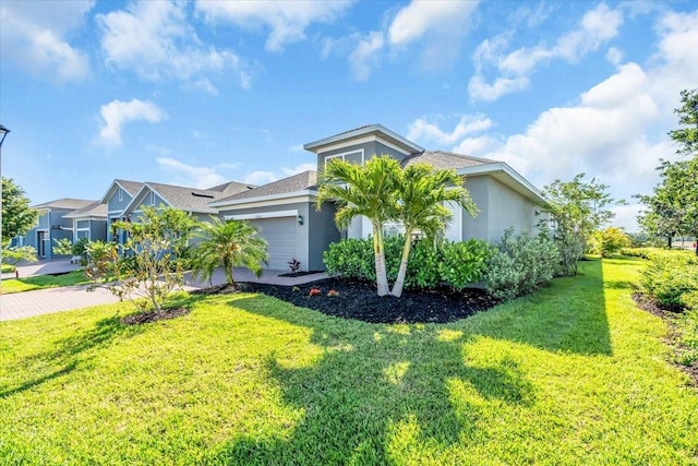 view of front of property with a garage, stucco siding, driveway, and a front yard