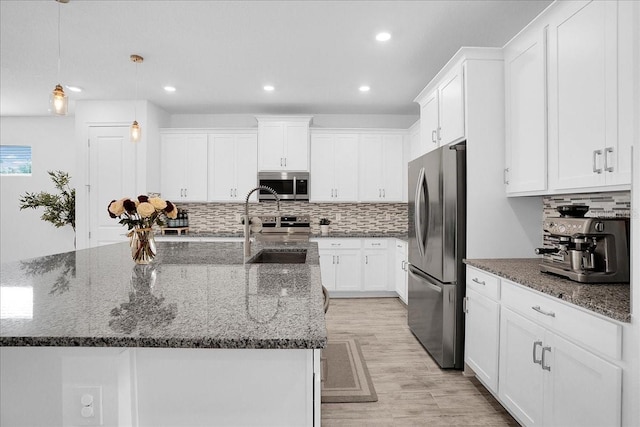 kitchen with decorative backsplash, recessed lighting, white cabinetry, light wood-style flooring, and appliances with stainless steel finishes