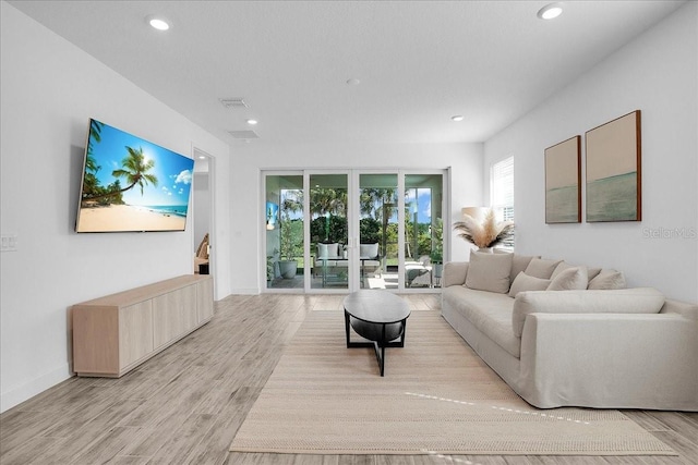 living area with recessed lighting, baseboards, visible vents, and light wood-type flooring