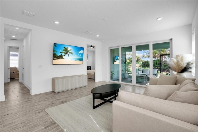 living area with baseboards, plenty of natural light, and recessed lighting