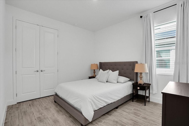 bedroom featuring baseboards, a closet, and light wood-type flooring