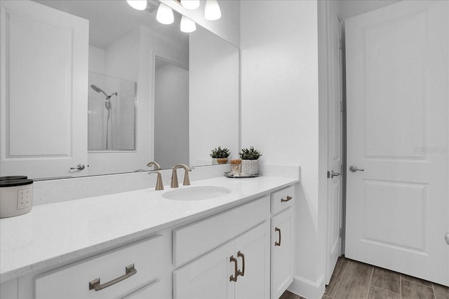 full bath with vanity, walk in shower, and wood finished floors