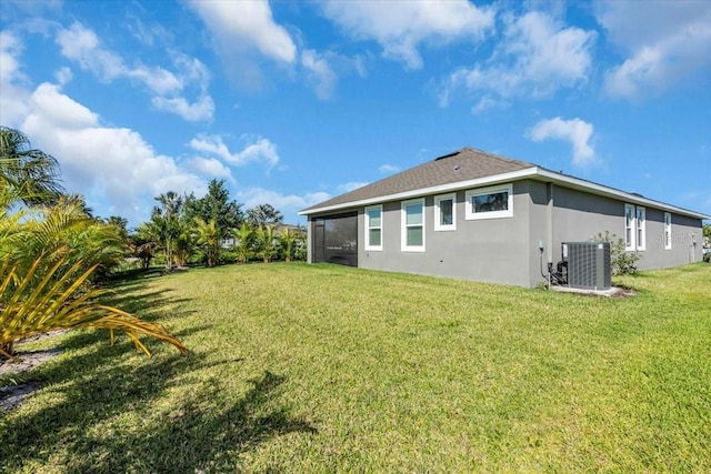 back of house with a lawn, a sunroom, stucco siding, and cooling unit