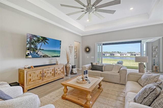 living room featuring ceiling fan, light hardwood / wood-style flooring, crown molding, and a raised ceiling