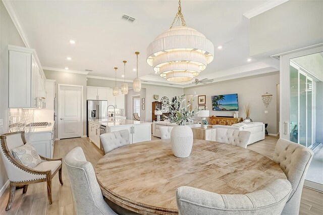 dining space with light wood-type flooring, a chandelier, and a healthy amount of sunlight