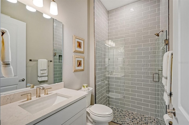 bathroom with an enclosed shower, vanity, and toilet