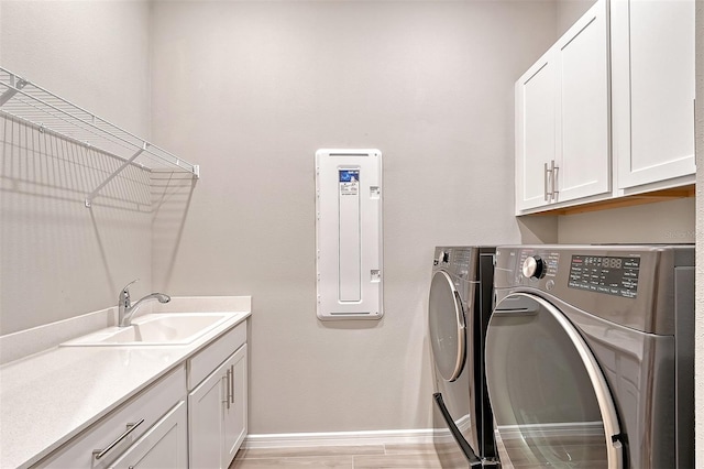 washroom featuring cabinets, light wood-type flooring, sink, and washing machine and dryer