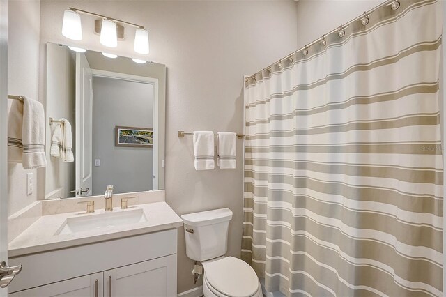 bathroom with walk in shower, vanity, and toilet