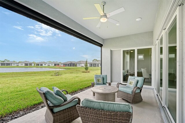 sunroom / solarium featuring a water view and ceiling fan