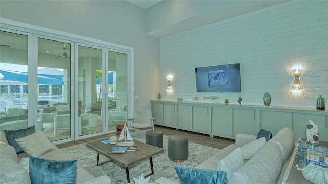 living room with light hardwood / wood-style flooring and a high ceiling