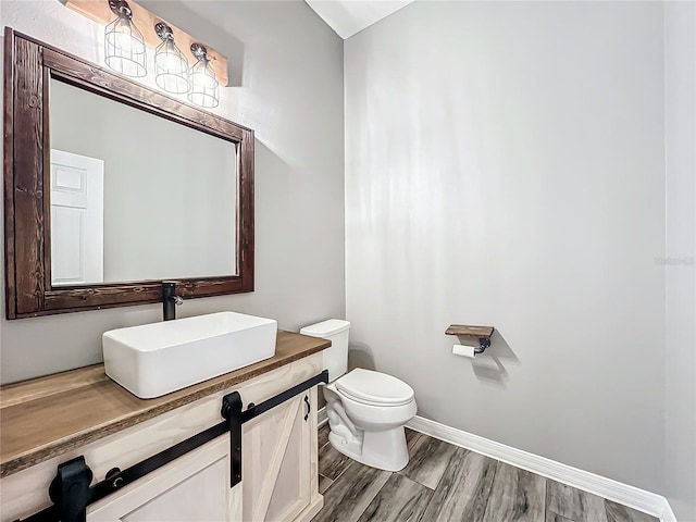 bathroom featuring hardwood / wood-style flooring, vanity, and toilet