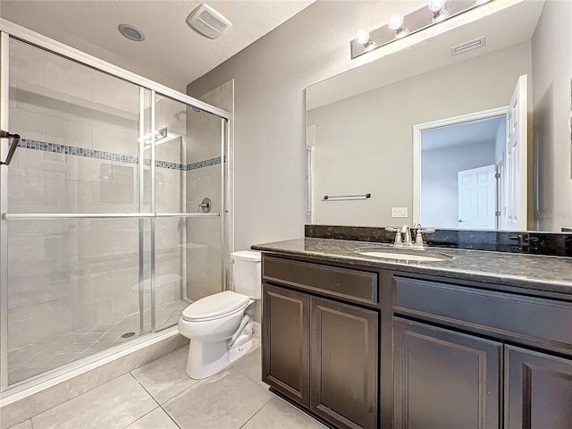 bathroom featuring tile patterned flooring, a textured ceiling, toilet, a shower with door, and vanity