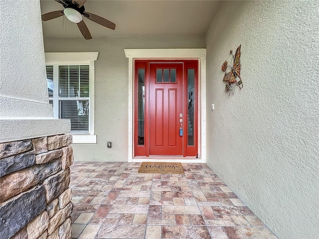 view of exterior entry featuring ceiling fan