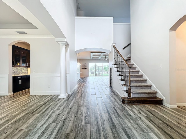 foyer with crown molding and dark wood-type flooring