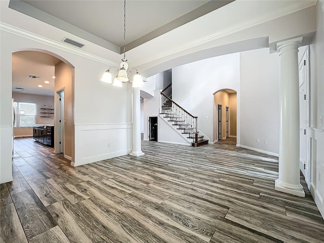 interior space featuring a tray ceiling, crown molding, dark wood-type flooring, and a notable chandelier