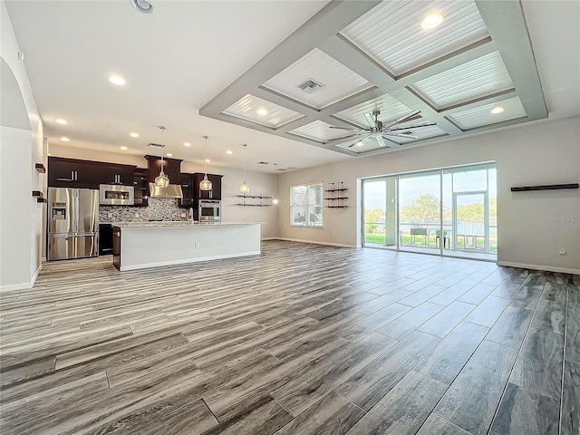 unfurnished living room with beam ceiling, ceiling fan, and coffered ceiling