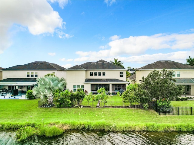 back of house with a yard and a water view