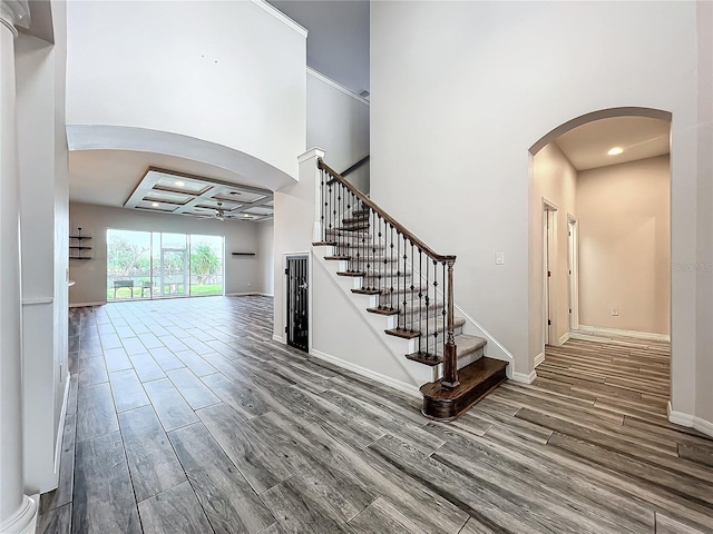 foyer entrance with ceiling fan and coffered ceiling