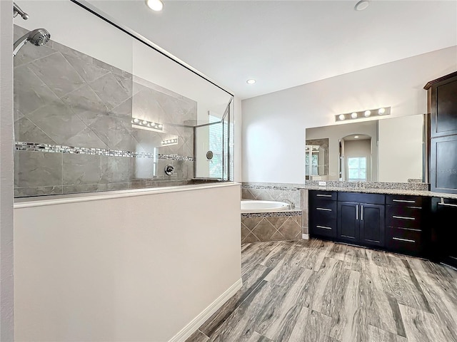 bathroom with vanity, independent shower and bath, and wood-type flooring