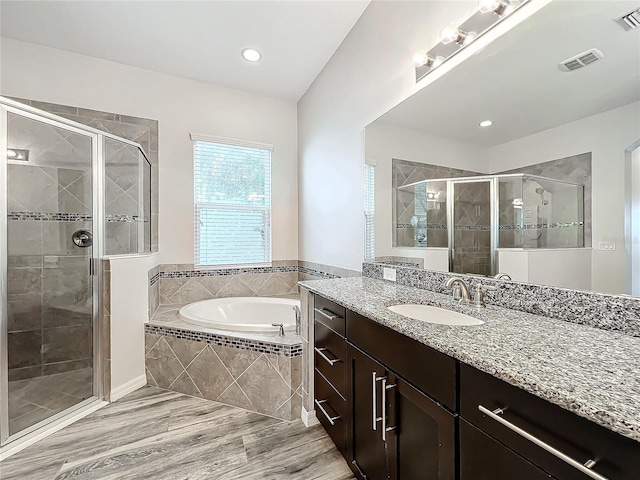 bathroom featuring separate shower and tub and vanity