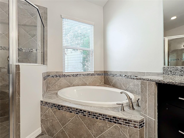 bathroom featuring vanity and independent shower and bath