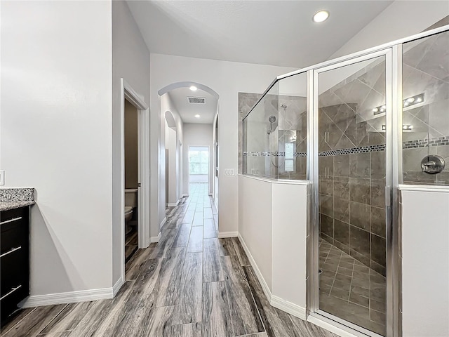 bathroom with vanity, toilet, and a shower with shower door