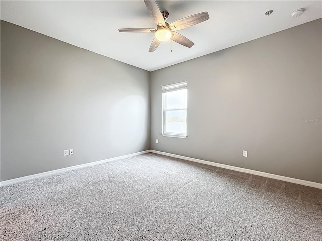 carpeted spare room featuring ceiling fan