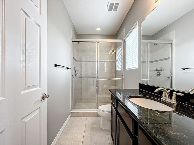 bathroom featuring tile patterned flooring, vanity, a shower with door, and toilet