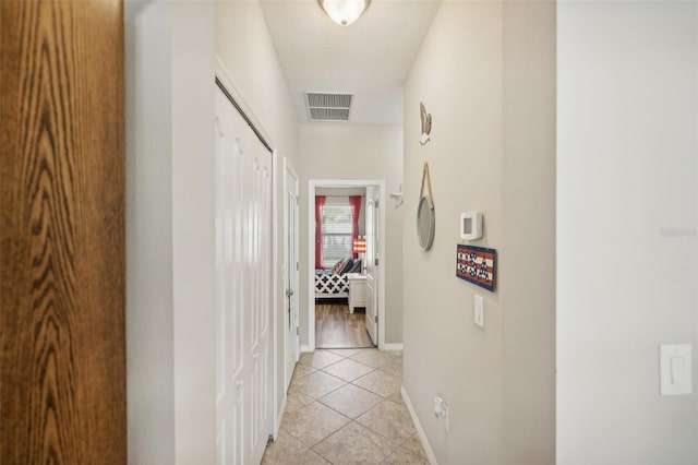 hall featuring light tile patterned floors