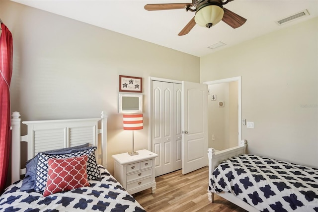 bedroom with light hardwood / wood-style floors, ceiling fan, and a closet