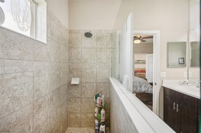 bathroom featuring tiled shower, vanity, and ceiling fan