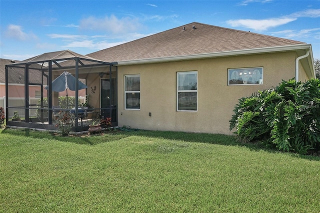 rear view of house with a lanai and a lawn