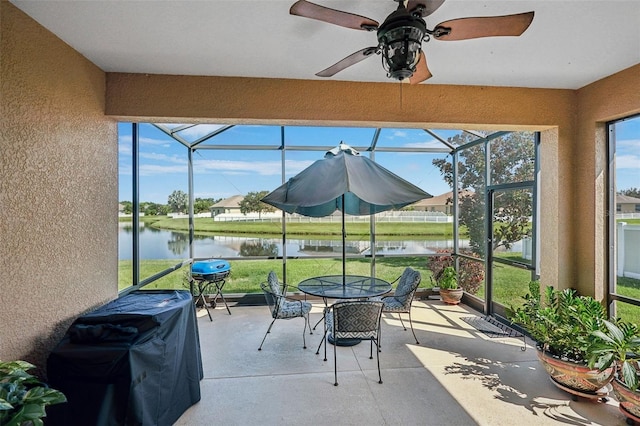 sunroom / solarium featuring a water view, ceiling fan, and a wealth of natural light