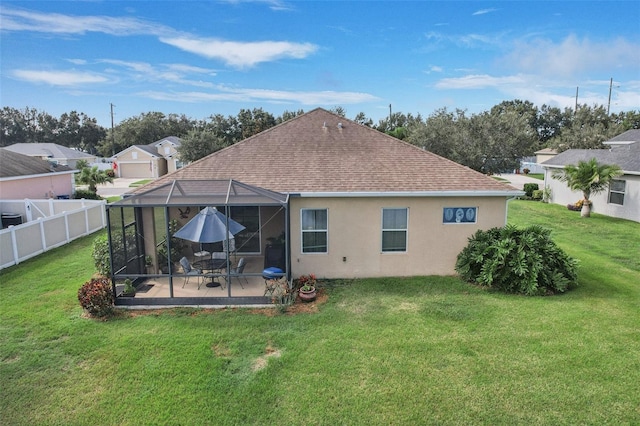 rear view of house with a patio, a yard, and a lanai