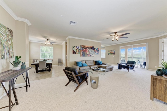 living room featuring ornamental molding, a wealth of natural light, ceiling fan, and light colored carpet