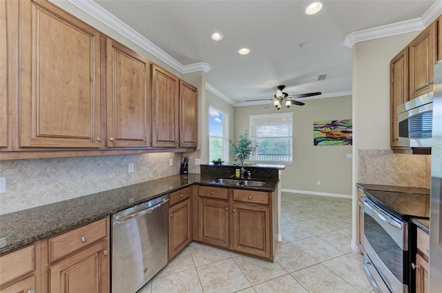 kitchen with ceiling fan, appliances with stainless steel finishes, ornamental molding, and dark stone countertops