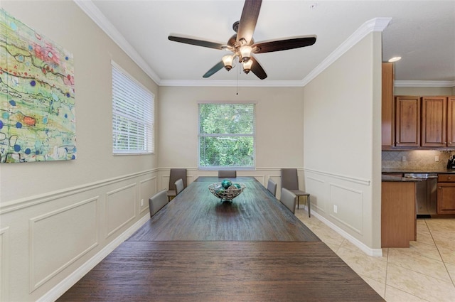 tiled dining area featuring ceiling fan and crown molding