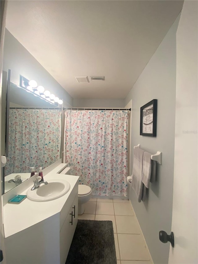 bathroom with tile patterned flooring, vanity, and toilet