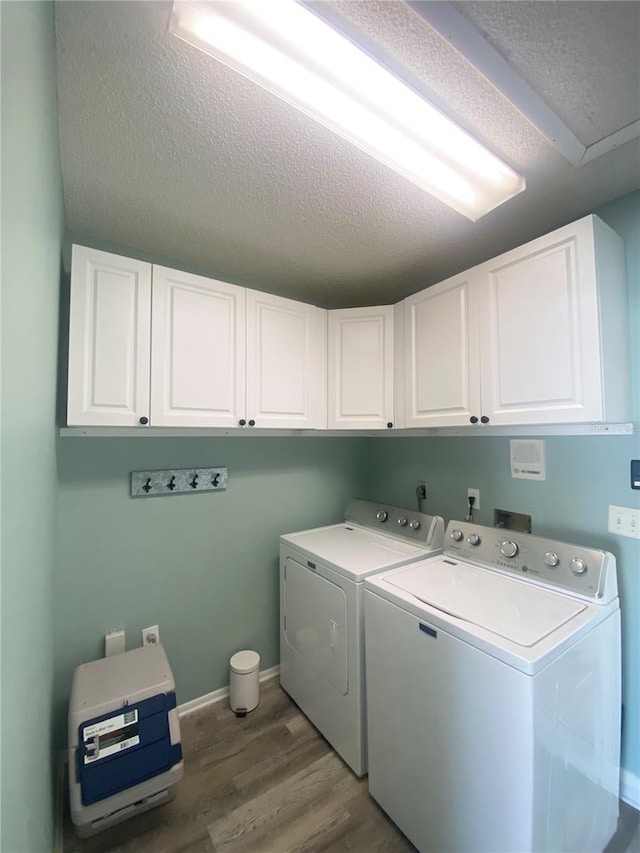 laundry room with dark hardwood / wood-style flooring, cabinets, independent washer and dryer, and a textured ceiling