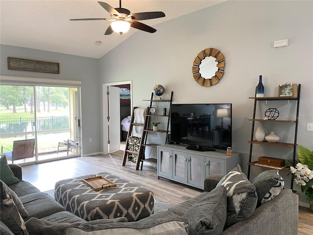 living room with ceiling fan, light hardwood / wood-style floors, and high vaulted ceiling