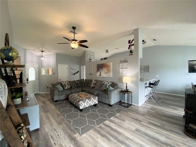 living room with ceiling fan, wood-type flooring, and vaulted ceiling