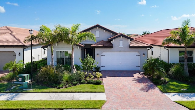 mediterranean / spanish house featuring a front lawn and a garage