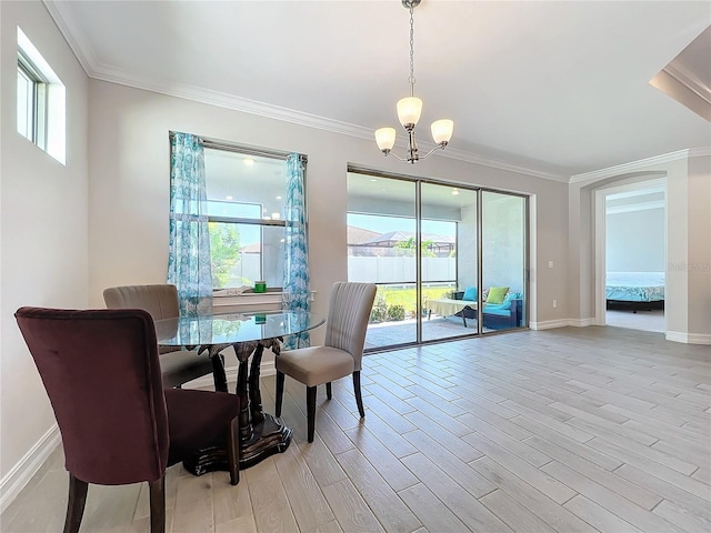 dining space with an inviting chandelier, crown molding, light hardwood / wood-style floors, and a healthy amount of sunlight