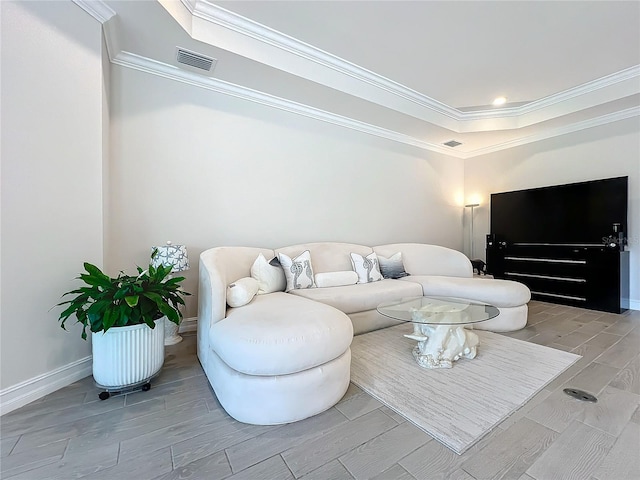 living room featuring light wood-type flooring, a raised ceiling, and ornamental molding