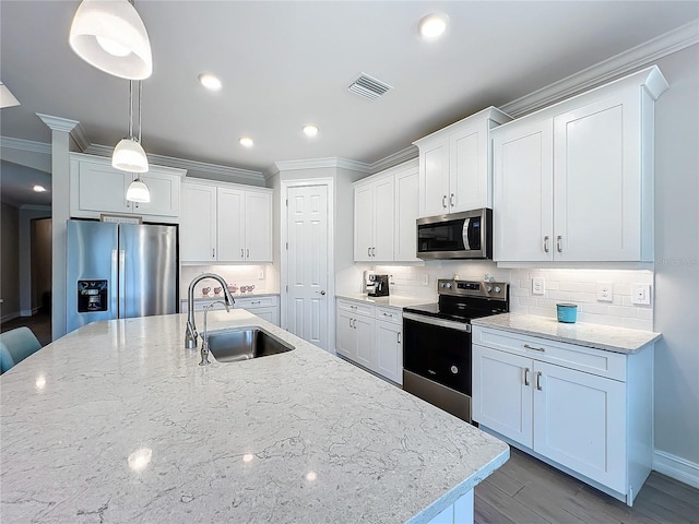 kitchen with white cabinetry, appliances with stainless steel finishes, decorative light fixtures, and sink