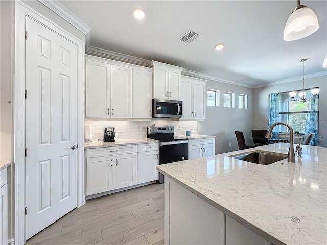 kitchen featuring sink, white cabinets, stainless steel appliances, decorative light fixtures, and light stone countertops