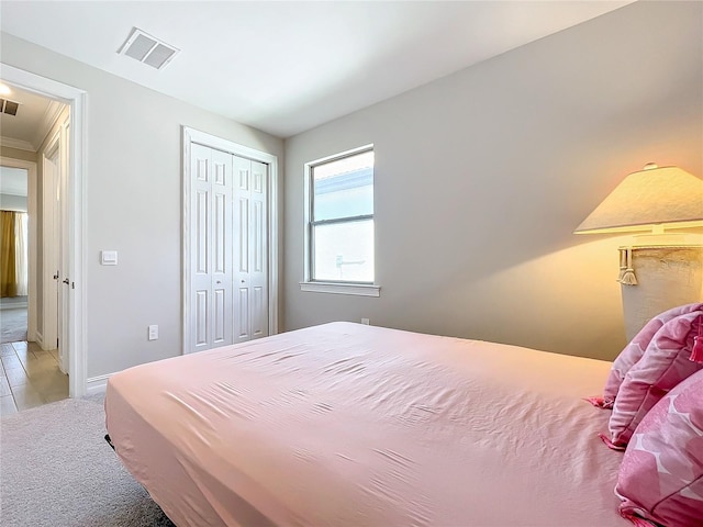 bedroom with crown molding, light carpet, and a closet