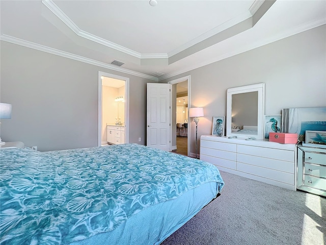 bedroom with carpet flooring, ensuite bathroom, a tray ceiling, and ornamental molding